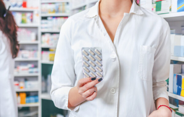 Profissional segura medicamento em farmácia; varejistas alimentares perderam participação no mercado