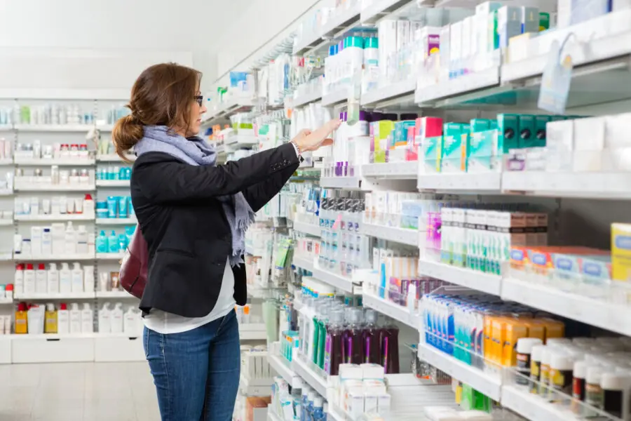 Female Customer Choosing Product At Pharmacy medicamentos mais vendidos